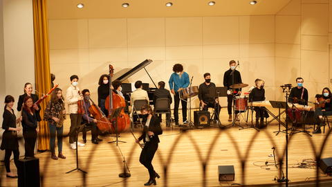 Students preparing to perform music on stage